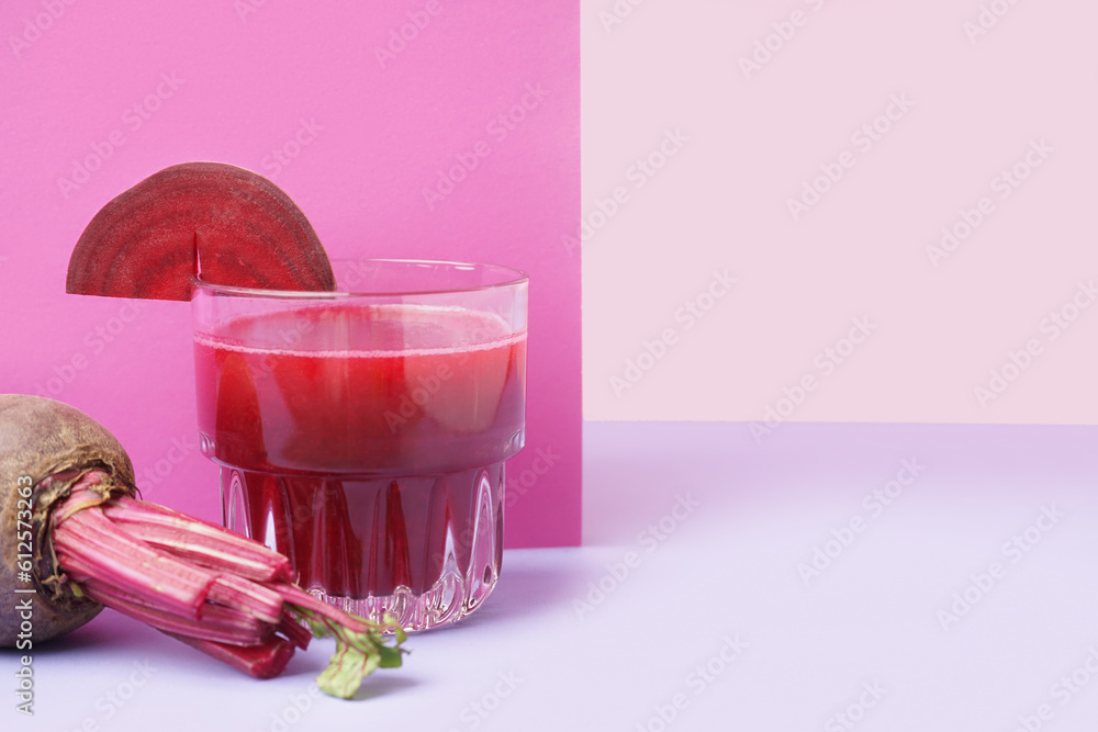 Glass of healthy beet juice on colorful background