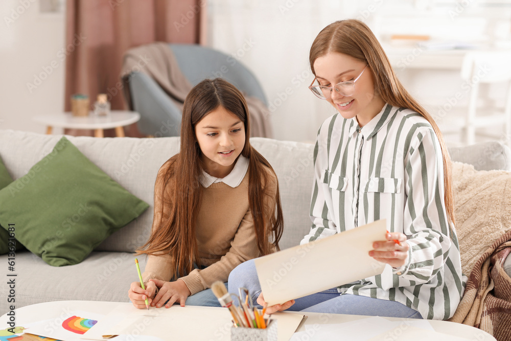 Drawing teacher giving private art lesson to little girl at home