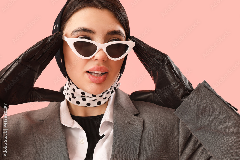 Stylish young woman in sunglasses and leather gloves on pink background, closeup