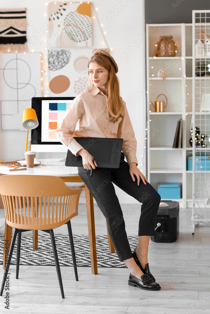 Female graphic designer with tablet working in office
