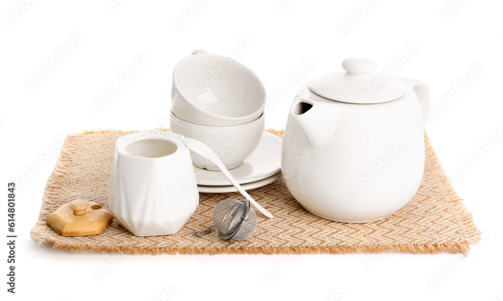 Wicker mat with teapot, sugar bowl and cups isolated on white background