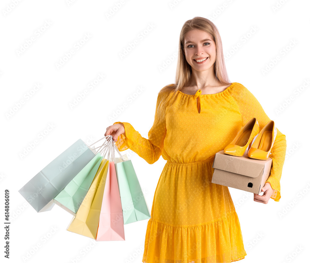 Young woman with shoes and shopping bags on white background