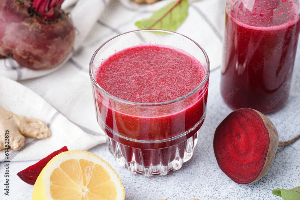 Glass of fresh beetroot juice and ingredients on light background