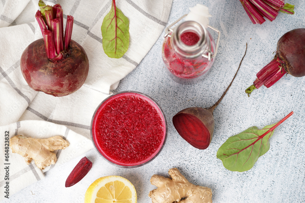 Bottle and glass of fresh beetroot juice with ingredients on light background