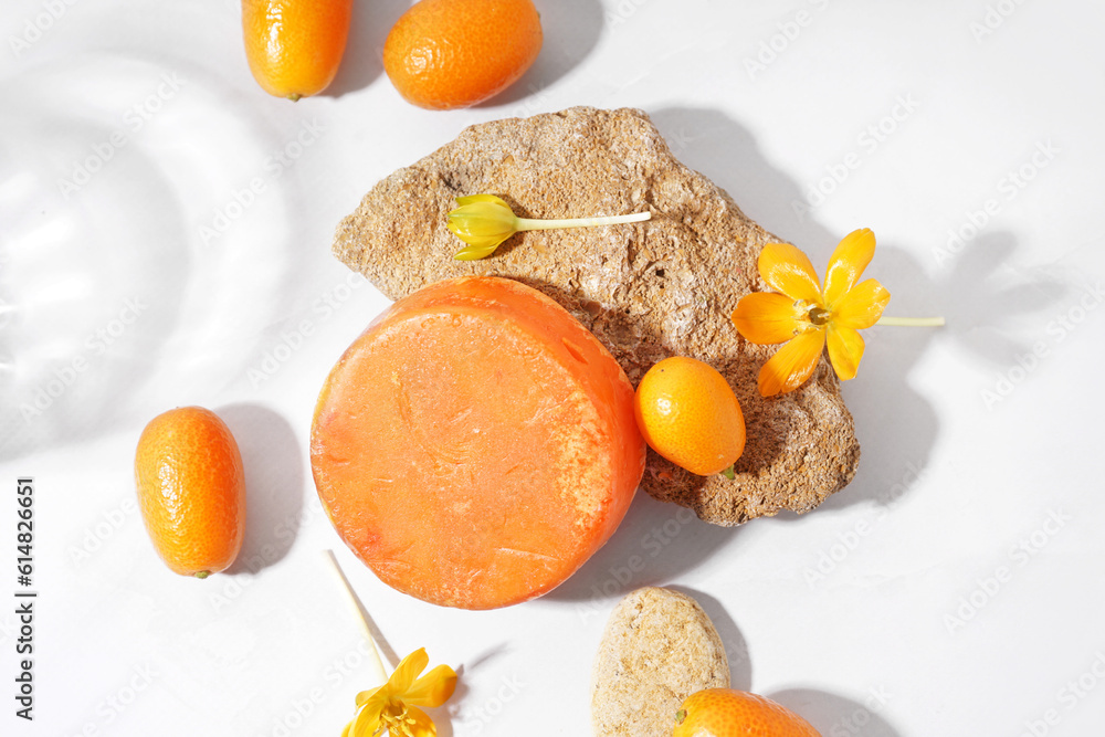 Handmade solid shampoo, flowers and kumquats on light background, closeup