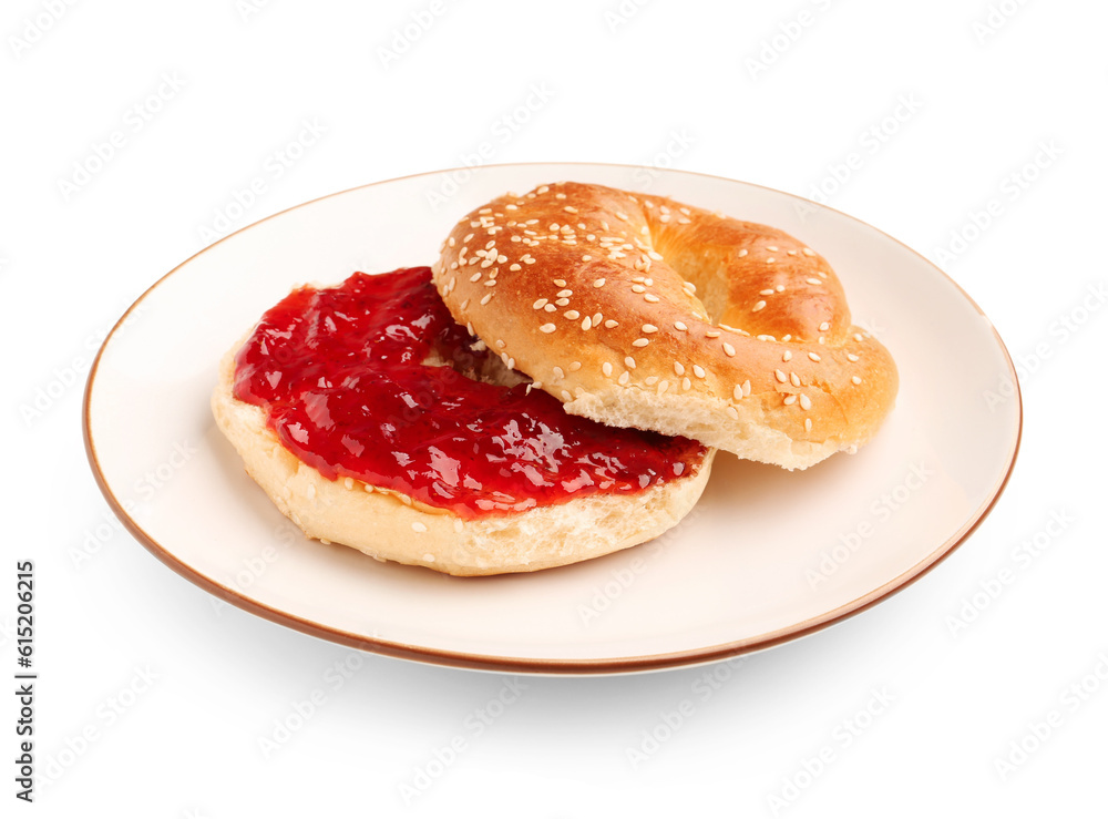 Plate of tasty bagel with strawberry jam on white background