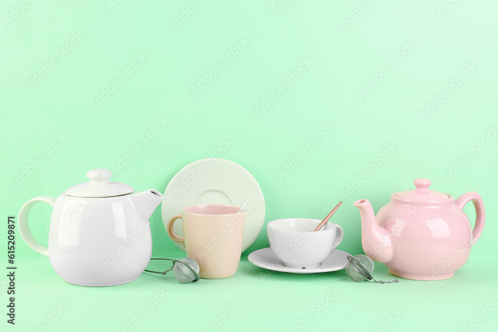 Stylish tea set on green background