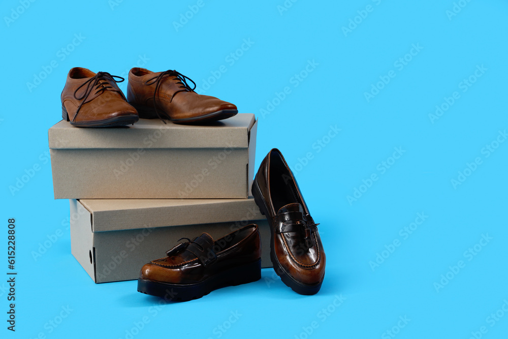Cardboard boxes with different male shoes on blue background