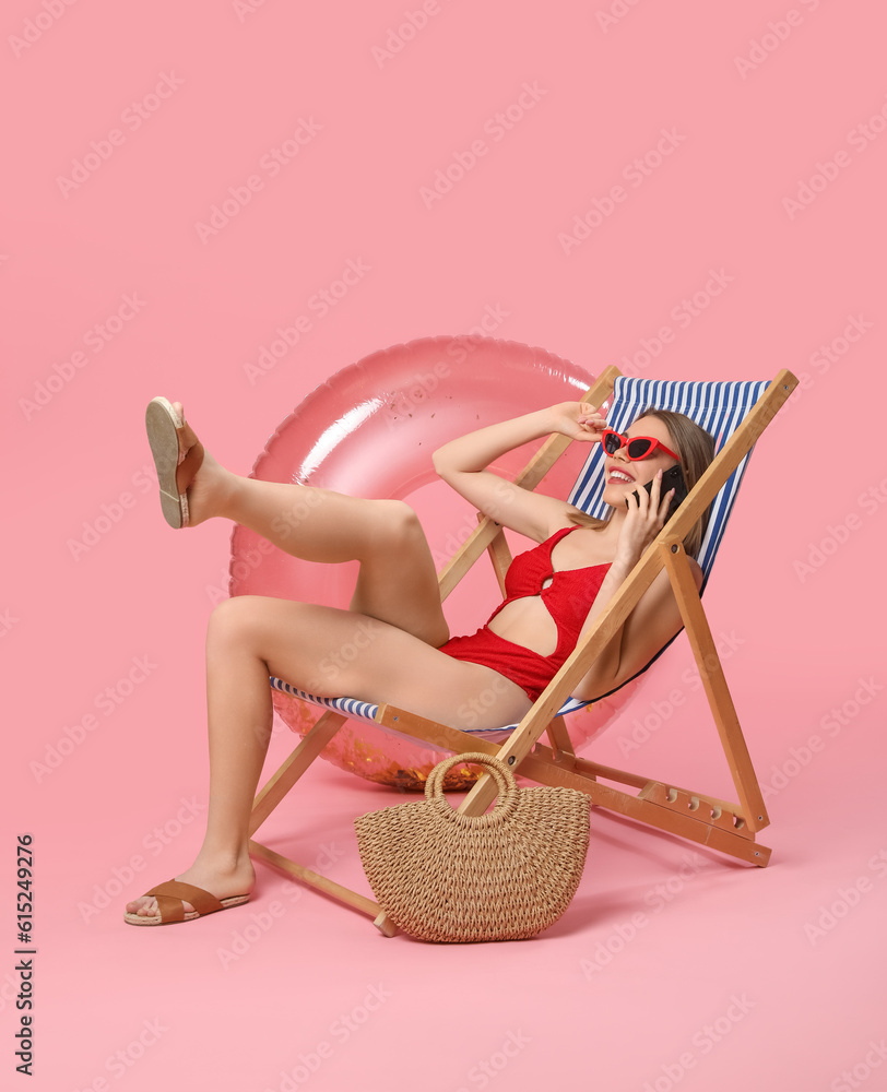 Young woman in swimsuit on pink background