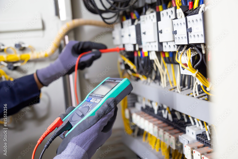 Electrician engineer tests electrical installations and wires on relay protection system. Adjustment