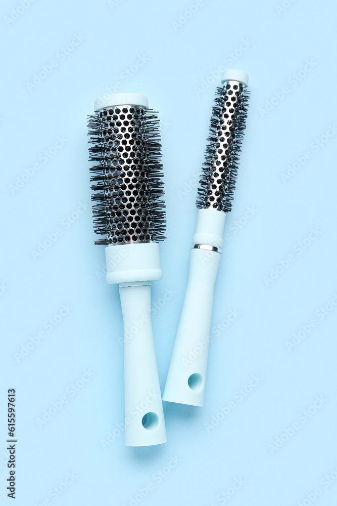 Round hair brushes on blue background