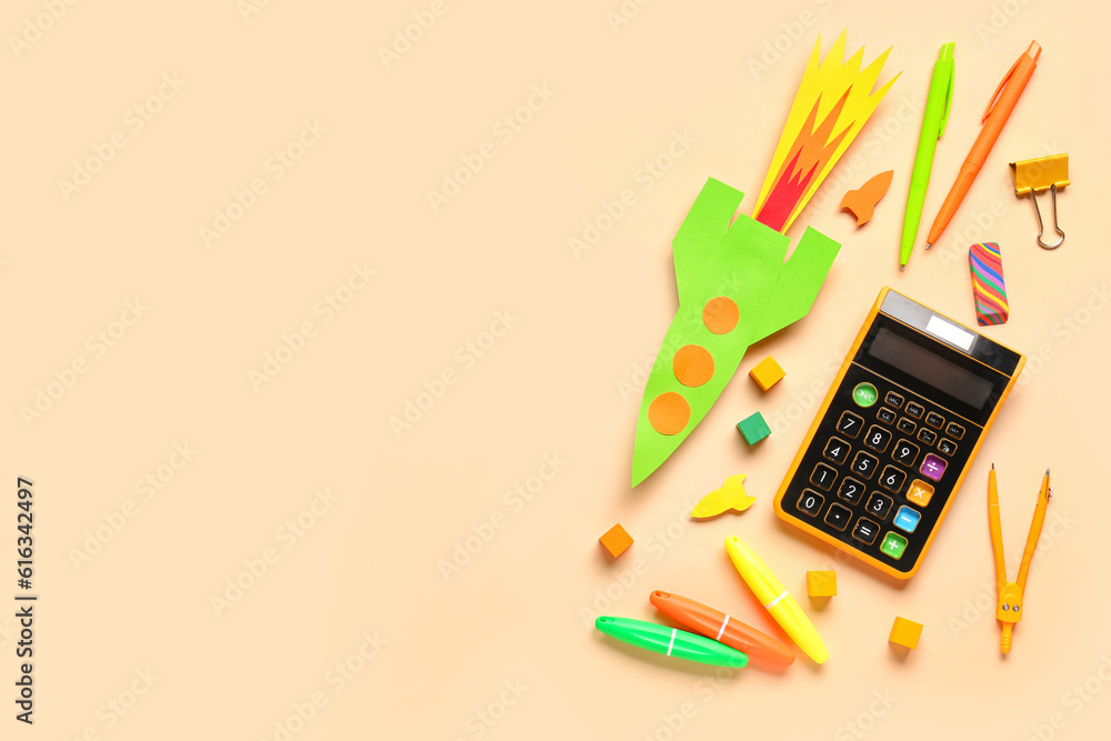Paper color rockets with calculator, pens and compass on beige background