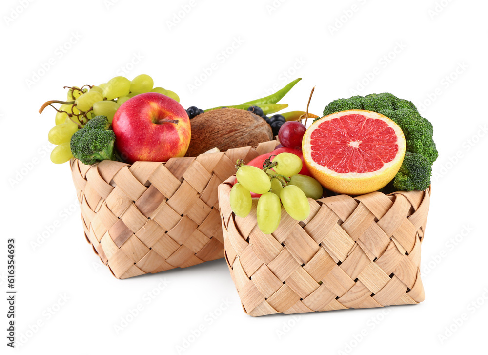 Wicker baskets with different fresh fruits and vegetables on white background