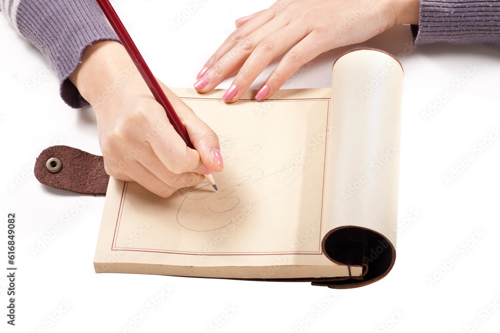 A hand is drawing a picture with a red pencil