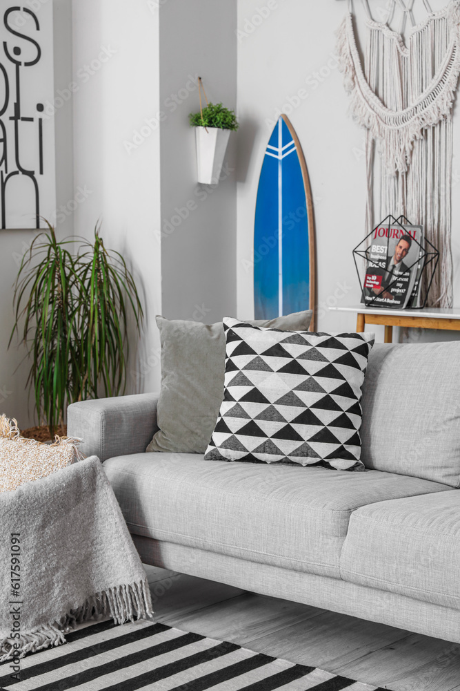 Interior of stylish living room with surfboard and sofa