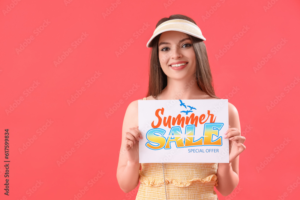 Young woman holding paper with text SUMMER SALE on red background