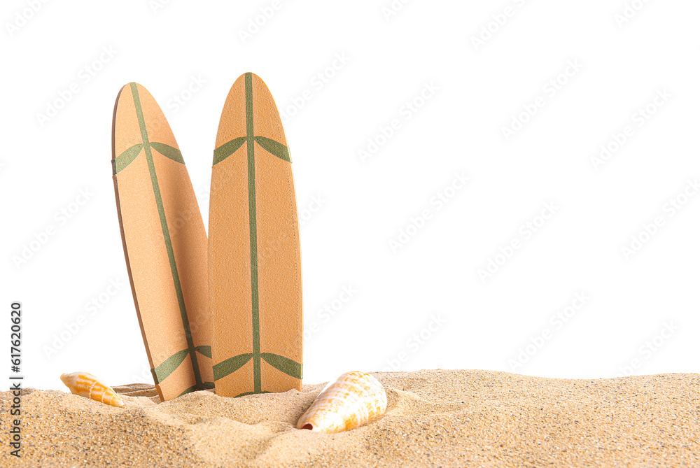 Mini surfboards with seashells on sand against white background