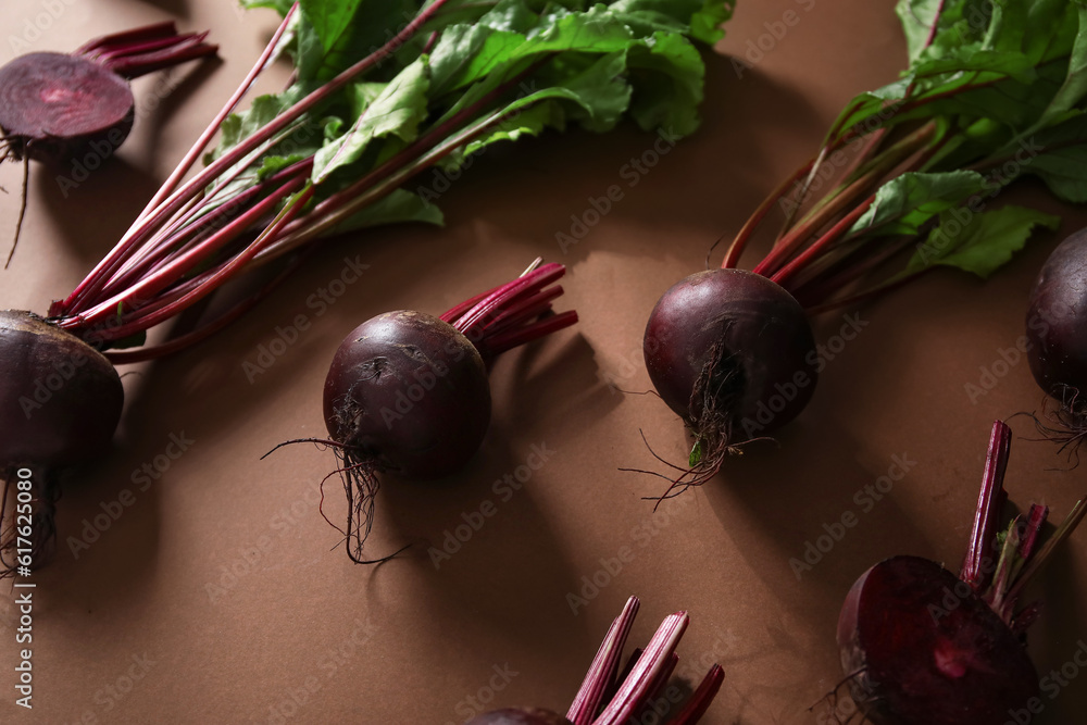 Fresh beets with green leaves on brown background