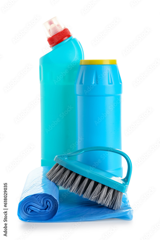 Bottles of detergent, brush and roll of garbage bags isolated on white background