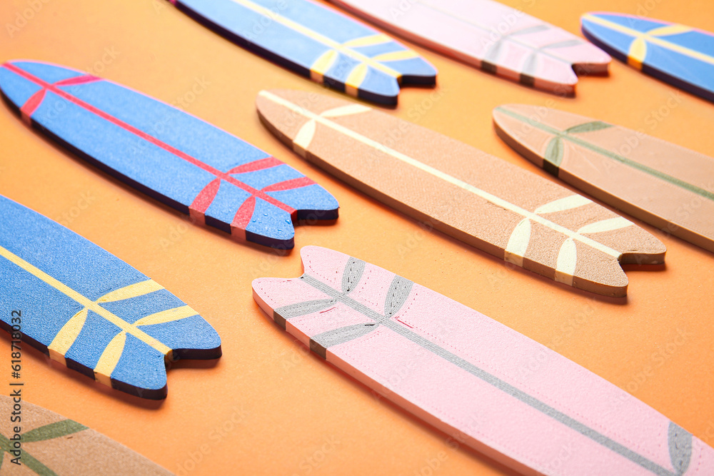 Mini different colorful surfboards on orange background