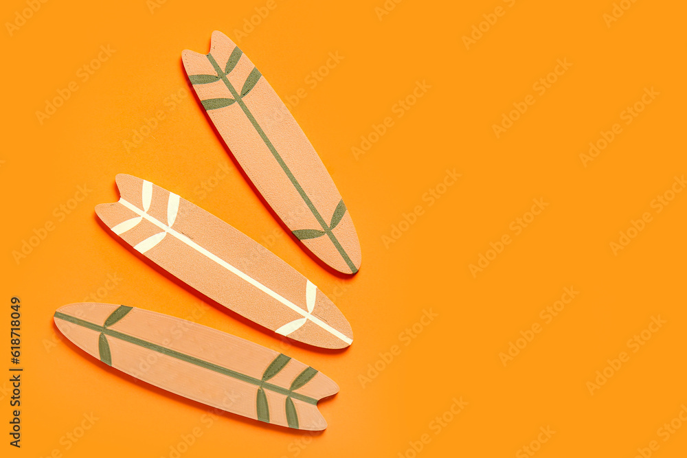 Mini different surfboards on orange background
