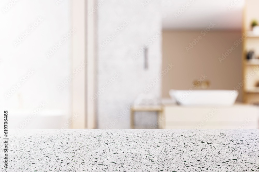 Front view of empty stone table top in bathroom interior with blurred background, product presentati