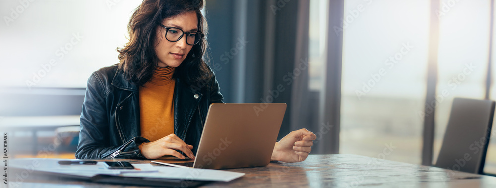 Asian business woman working on a laptop in a professional office