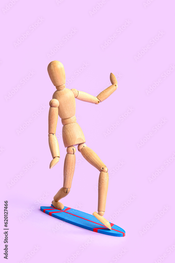 Creative composition with mini surfboard and wooden mannequin on lilac background