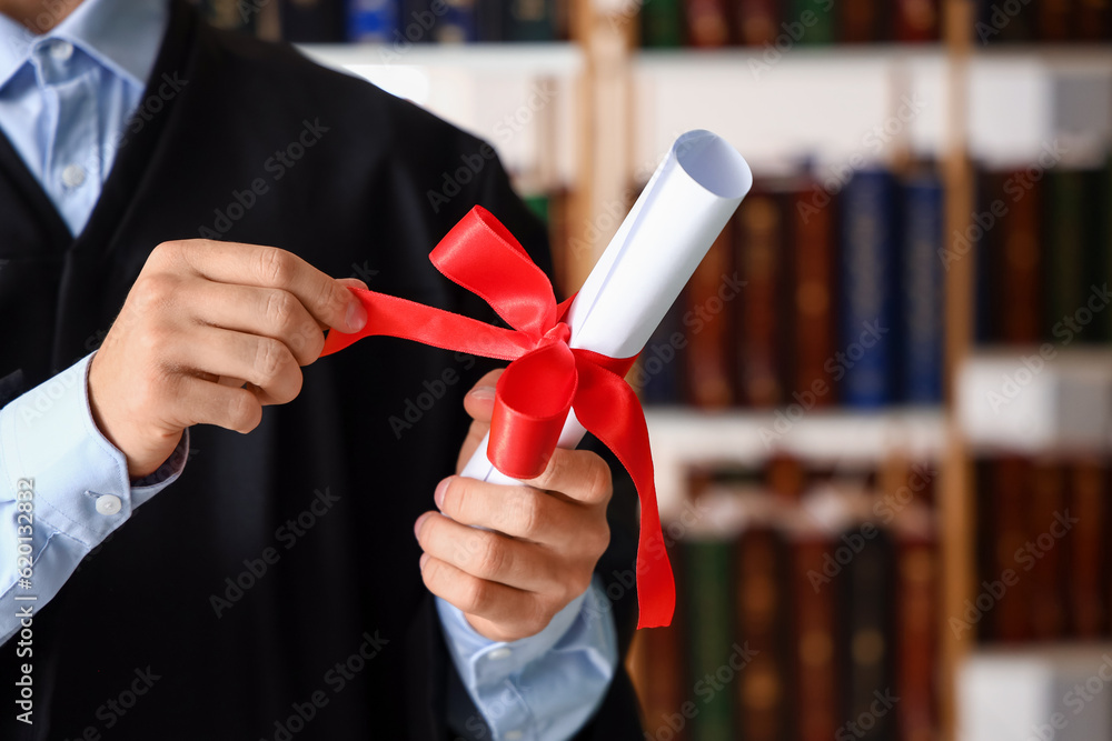Male graduate student with diploma at university, closeup