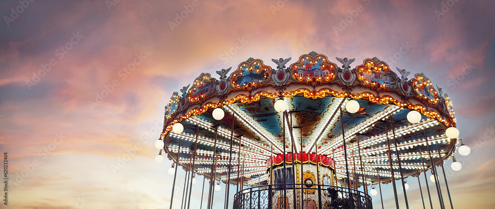 Part of popular vintage carousel (merry-go-round) by the Eiffel Tower in Paris on  sky sunset backgr