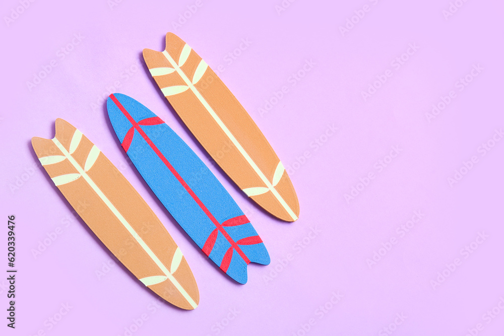 Different mini surfboards on lilac background