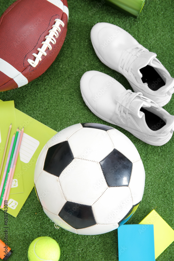 Sneakers with sport balls and different stationery on color background