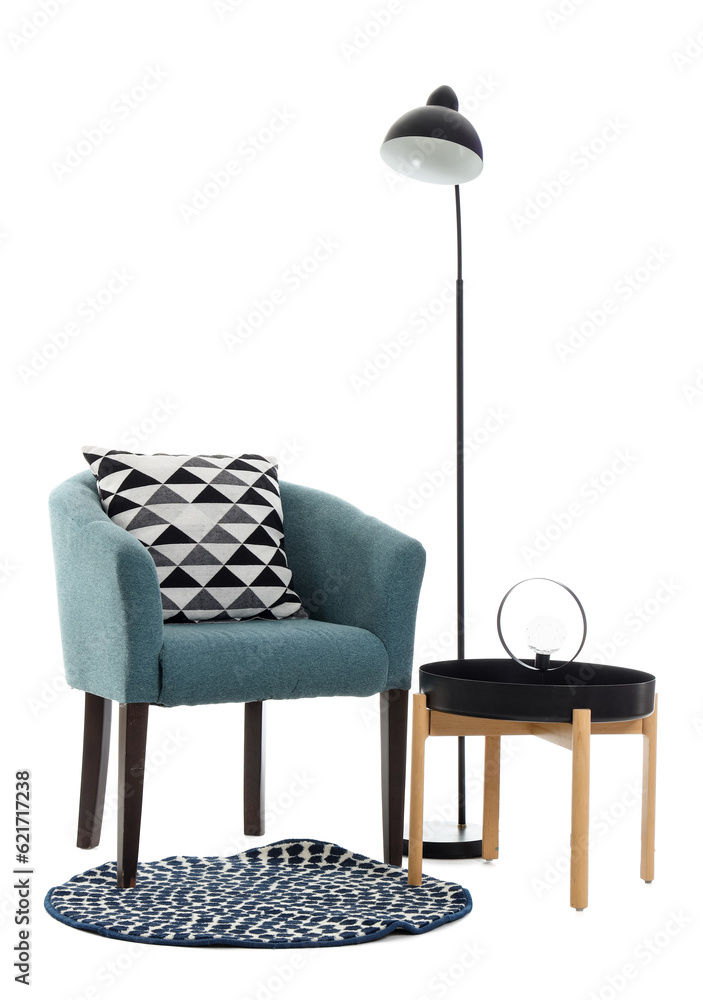 Soft armchair with table, lamps and rug on white background
