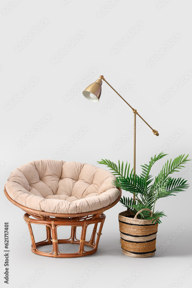 Cozy armchair with lamp and palm tree on white background