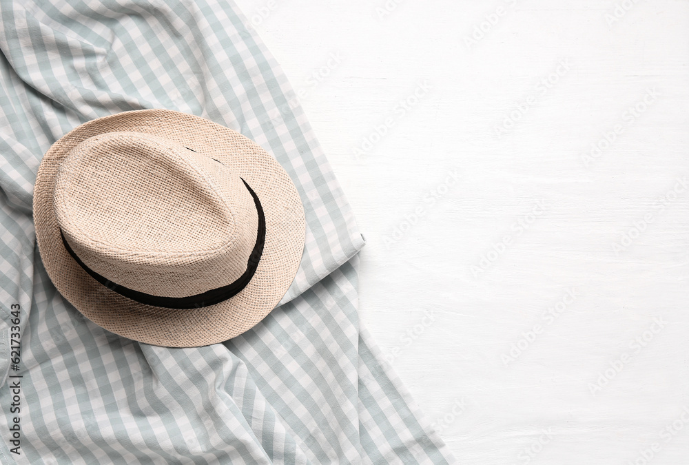Clean napkin with stylish hat on light wooden background