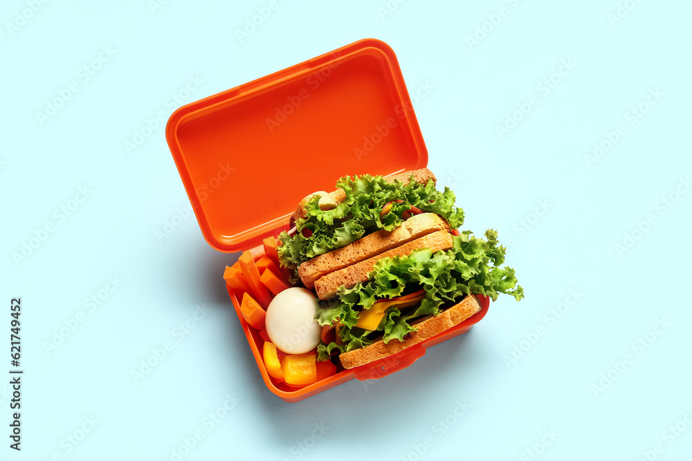 Lunchbox with tasty food on blue background