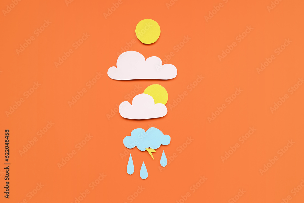 Paper sun with clouds and rain drops on red background. Weather forecast concept