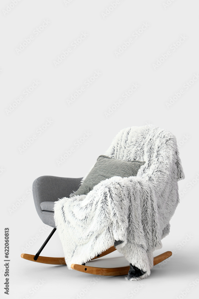 Rocking chair with cushion and plaid on white background