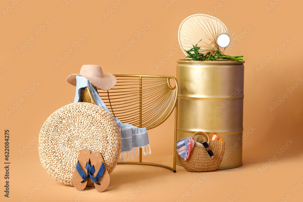Chair with barrel and beach accessories on beige background. Travel concept
