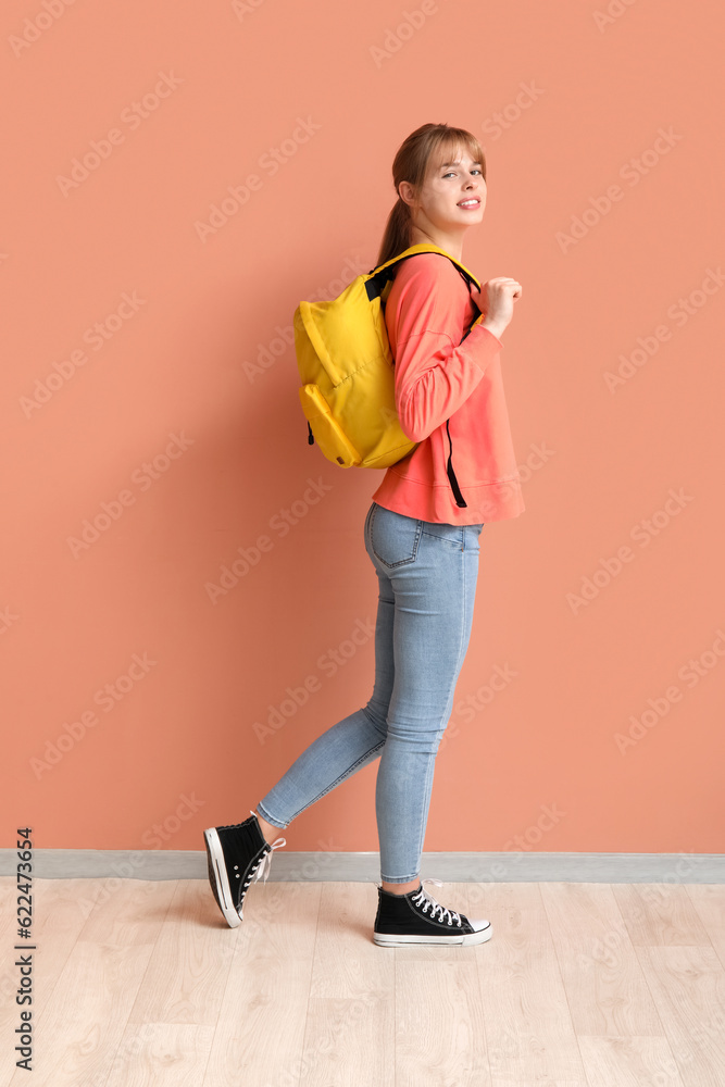 Female student with backpack near color wall
