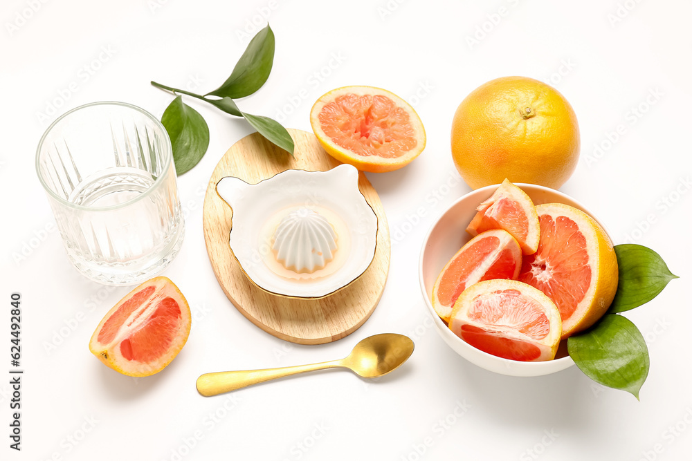 Composition with pieces of ripe grapefruit, juicer and glass on white background