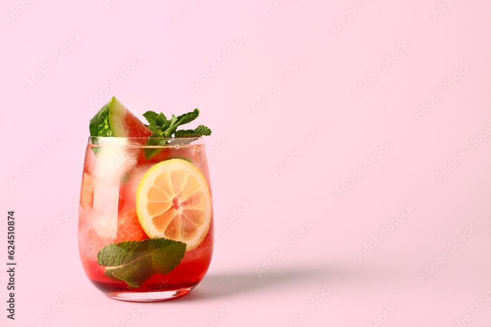 Glass of fresh watermelon lemonade with mint on pink background