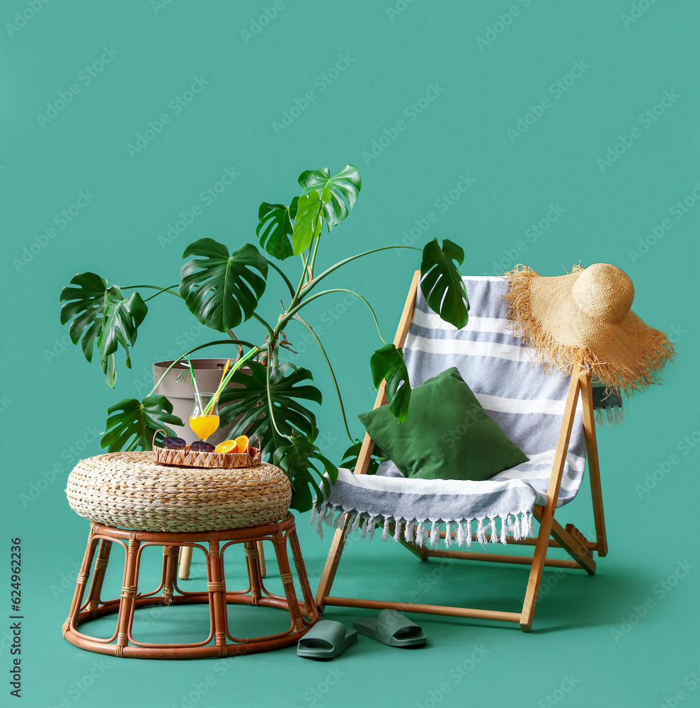 Comfortable deckchair with ottoman and beach accessories on turquoise background. Travel concept