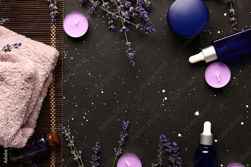 Frame made of cosmetic products, spa accessories and lavender flowers on dark background