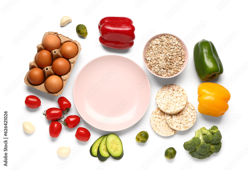 Empty plate, vegetables, eggs and bowl of oatmeal on white background