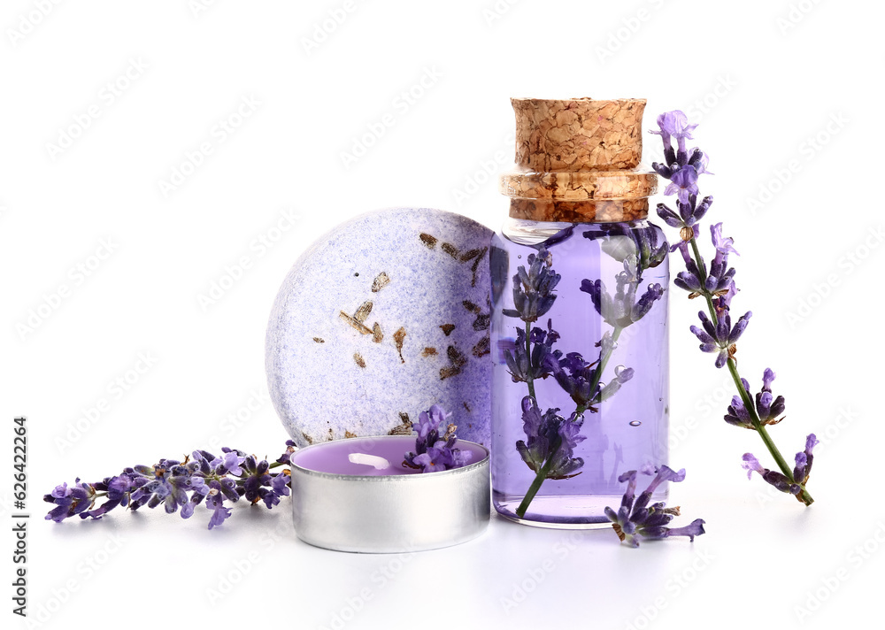 Bottle of essential oil, soap bar, candle and lavender flowers on white background