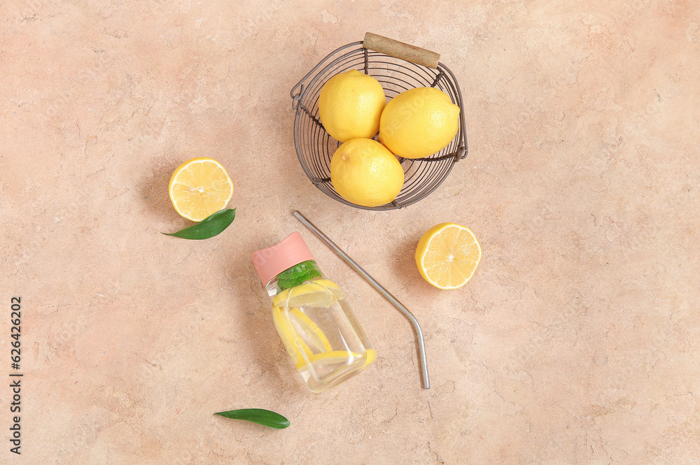Sports bottle of infused water with lemon and mint on pink table