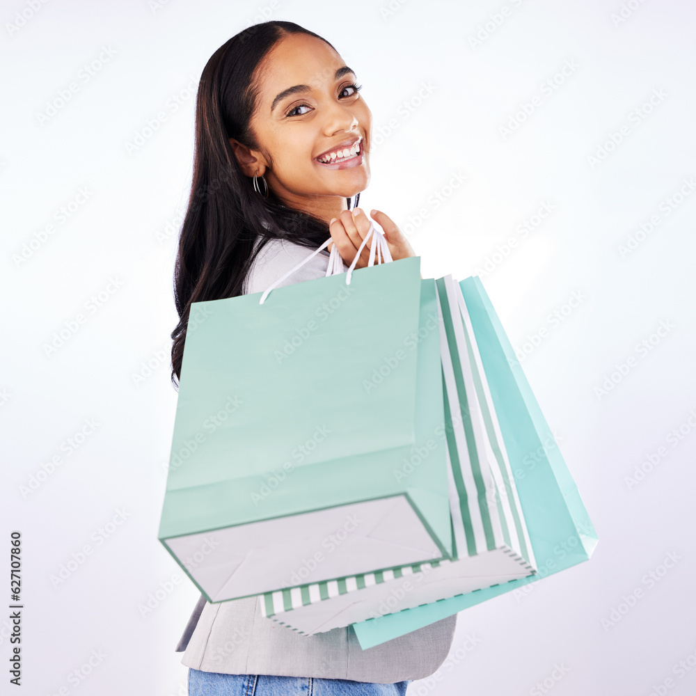 Portrait, woman and bag of shopping in studio, white background and fashion deal in retail package. 