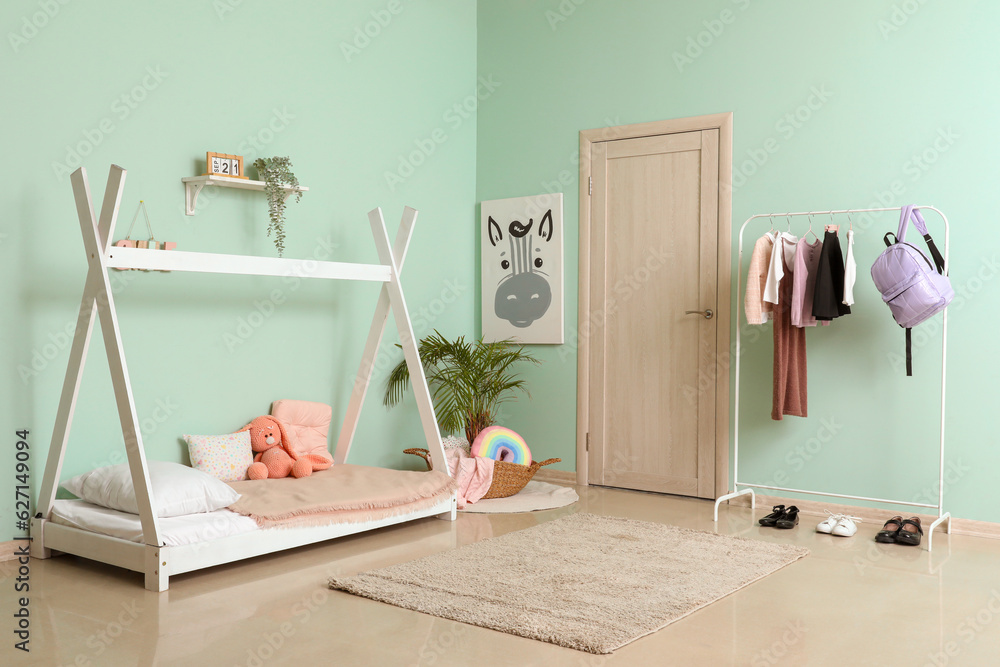 Stylish interior of childrens bedroom with school uniform and backpack