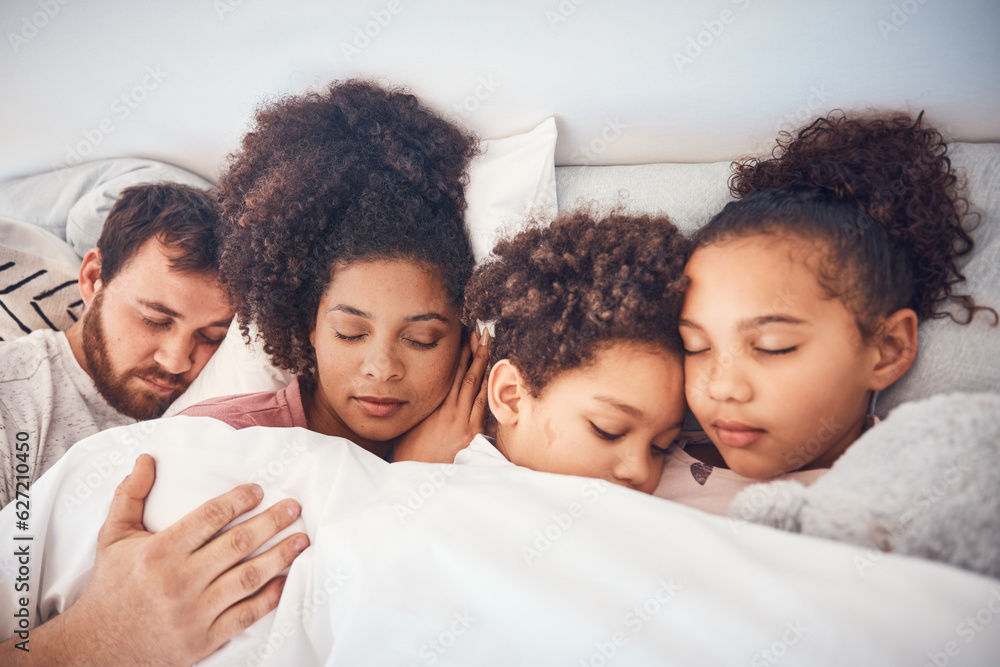 Family, sleeping and together in bed at home for security, bonding and comfort. Healthy, mixed race 
